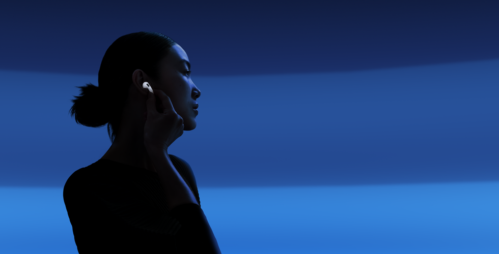 Човек, който с палеца и показалеца си държи дръжката на своите AirPods 5, за да превключва между режимите на слушане