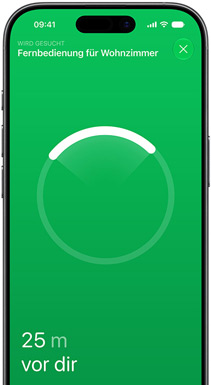 iPhone, das Display zeigt die „Wo ist?“ App, der Text lautet „Fernbedienung Wohnzimmer suchen“, kreisförmiger Ortungsring mit hellem Bogen, der in Richtung der Fernbedienung zeigt, Text „24 m vor dir“