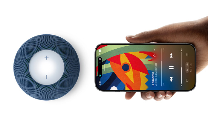 HomePod mini 2 y iPhone: Una mano sujeta un iPhone junto a un HomePod mini 2 azul para mostrar la prestación Handoff
