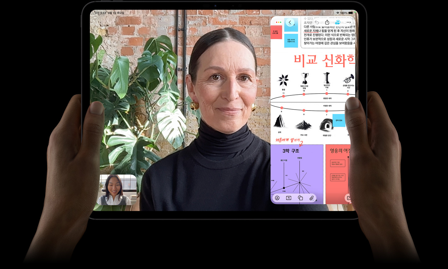 양손으로 잡은 가로 방향으로 놓인 스페이스 블랙 색상 iPad Pro. 둥근 형태의 모서리, 블랙 디스플레이 베젤이 보이고, 화면에는 FaceTime 통화 내용이 보이며, 화면의 오른쪽에는 텍스트, 도표, 손글씨 메모가 포함된 교육용 앱의 ‘비교 신화’ 프레젠테이션이 표시되어 있습니다.