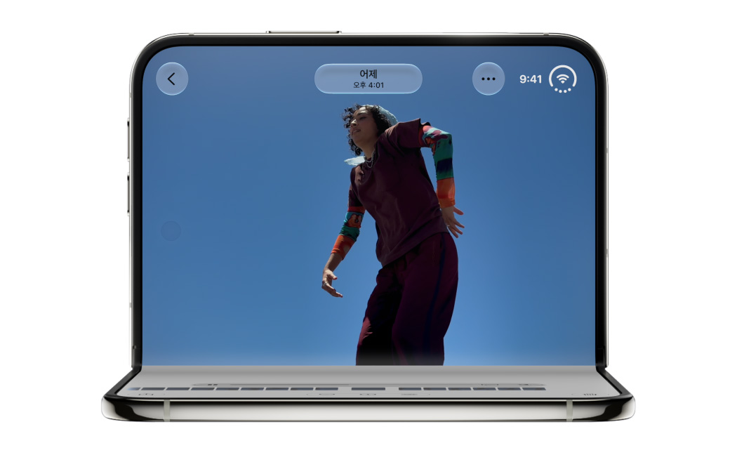 iPhone Duo가 화면이 밖을 향하도록 역 V자 형태를 이루며 가장자리로 세워져 있고, 스탠바이 모드에서 FaceTime 앱이 열려 있는 모습