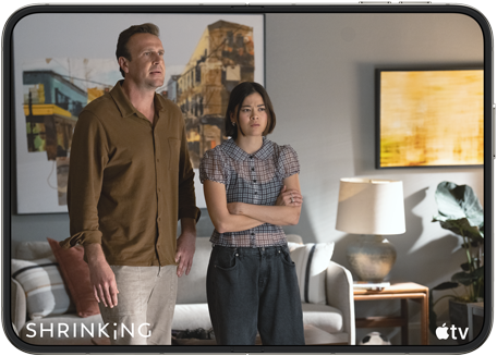 جهازا iPhone، مفتوحان في الوضع الأفقي، مع تشغيل مسلسل Shrinking من Apple TV على الشاشة