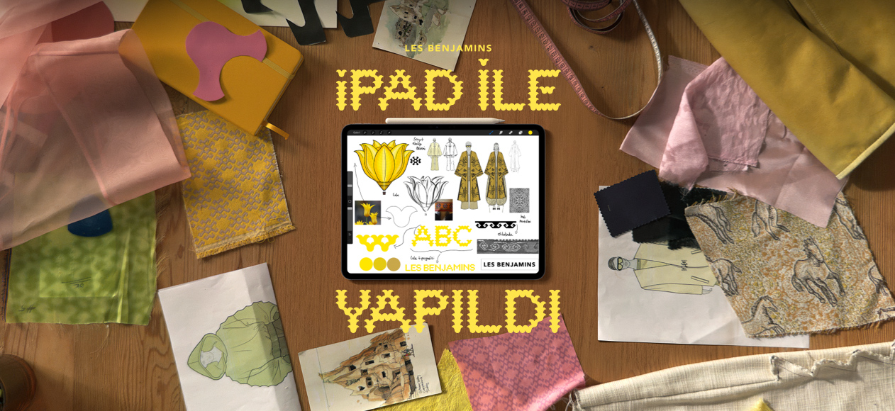 Ekranın ortasında sarı bir iPad ile Yapıldı tipografisinin eşlik ettiği; üzerinde farklı farklı renklerde ve türlerde kumaşların bulunduğu bir çalışma masası üzerinde yer alan iPad Pro ekranında Les Benjamins’in yeni koleksiyonunun eskizleri gösteriliyor.