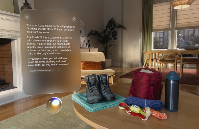 Apple Vision Proのビュー。登山靴などのアウトドア用品の左側にSiriがあり、その上に登山靴がリュックに収まるかどうかについてSiriとやり取りしている会話の画面が浮かんでいる