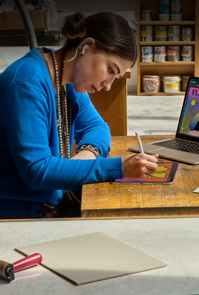 Opiskelija piirtää pöydän ääressä iPadilla Apple Pencilin avulla