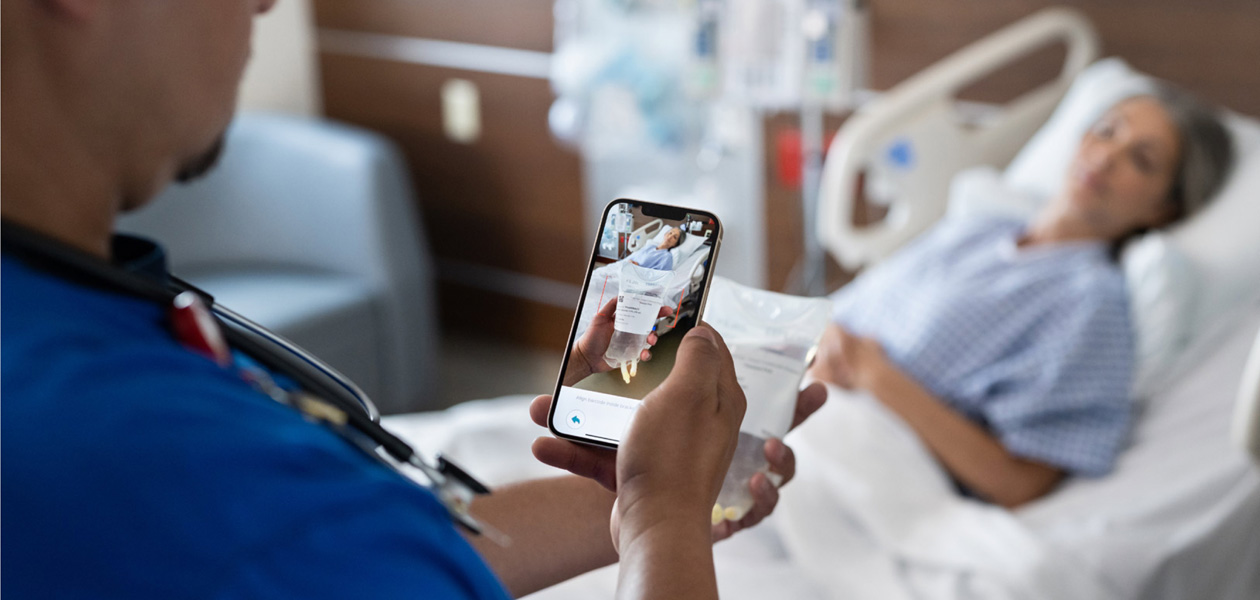 Uma enfermeira escaneia o medicamento de um paciente.