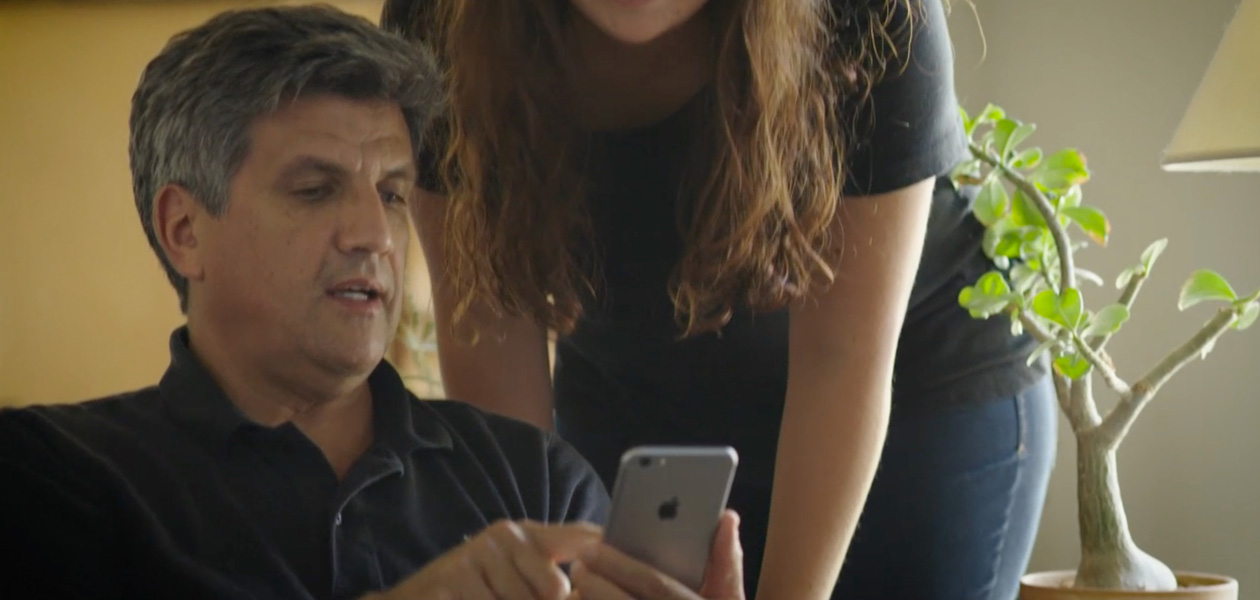 Um homem compartilhando suas informações de saúde em um iPhone com a mulher ao lado dele.