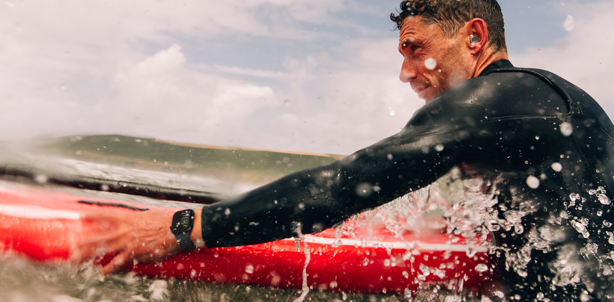 Un hombre hace surf con un Apple Watch puesto.