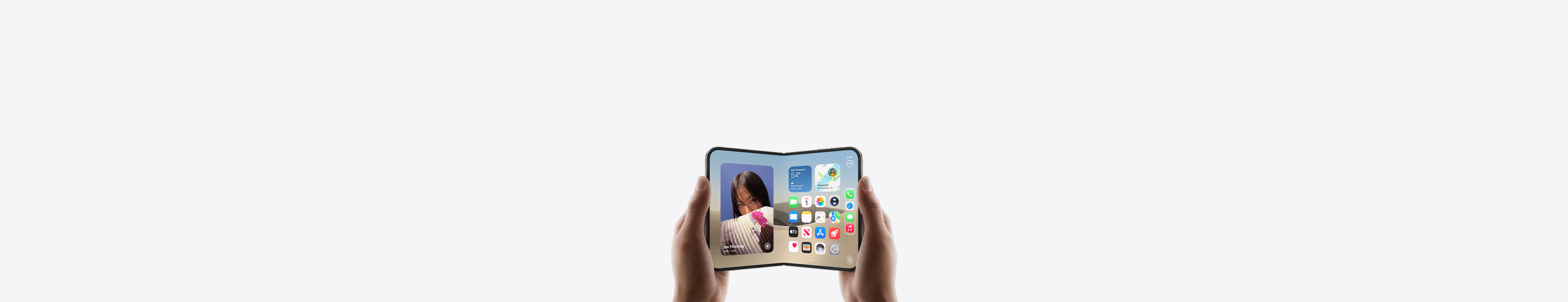 iPhone Duo, held by two hands in landscape orientation, unfolded, interior display features Home Screen.