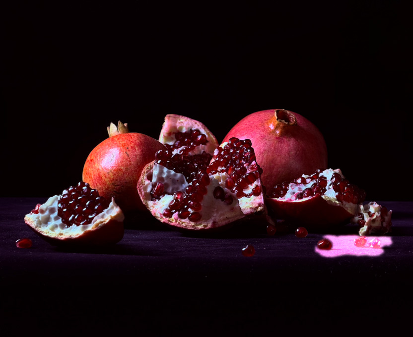 A close-up photograph of cracked-open pomegranates demonstrates the Clean Up feature, where unwanted objects in a photo are highlighted and deleted